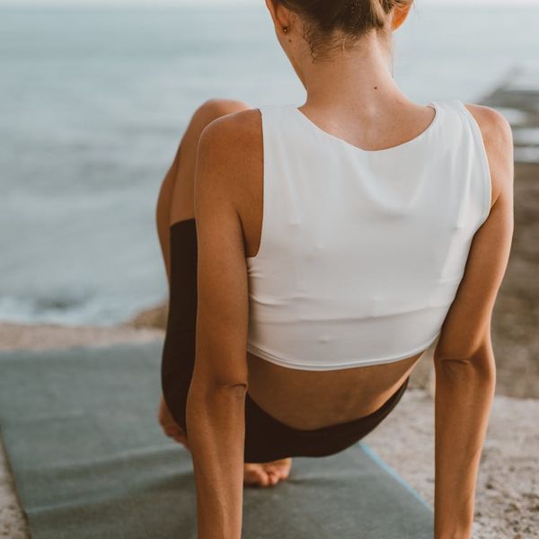 Person feeling energized and stretching outdoors at sunrise.